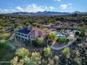 Scenic aerial view of property highlighting the pool, patio area, and tile roof set against a beautiful mountain range at 6524 E Rockaway Hills Dr, Cave Creek, AZ 85331