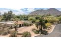 Elegant home exterior with a lush landscaped yard, a circular driveway, and desert foliage at 6735 E San Juan Ave, Paradise Valley, AZ 85253