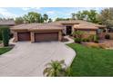 Gorgeous home with a well-manicured lawn and a three-car garage and long driveway at 844 E County Down Dr, Chandler, AZ 85249