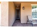 Cozy covered front porch with outdoor seating area and decorative lantern at 10307 E Tiburon Ave, Mesa, AZ 85212