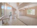 Bright foyer boasts tile flooring, high ceilings, neutral walls, and decorative hanging light fixtures at 10613 E Nacoma Dr, Sun Lakes, AZ 85248