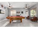 Bright game room featuring a red felt pool table, neutral walls, and plenty of natural light at 12798 W Dove Wing Way, Peoria, AZ 85383