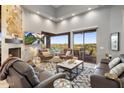 Bright living room featuring high ceilings, a modern fireplace, and a sliding glass door to a scenic balcony at 15135 E Sundown Dr, Fountain Hills, AZ 85268
