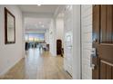 Open and airy hallway with tile flooring, flowing into a bright and spacious living area with natural light at 16566 W Saguaro Park Ln, Surprise, AZ 85387