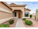 Attractive home entrance with desert landscaping, a wooden front door, and large window at 17132 E Hillcrest Dr, Fountain Hills, AZ 85268
