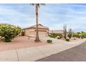 Expansive front yard showcases mature landscaping, including a palm tree, leading to a well-maintained single story home at 17132 E Hillcrest Dr, Fountain Hills, AZ 85268