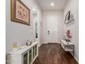 Bright foyer with wood floors, a white front door, decorative furniture, and complementary wall decor at 18422 W Clinton St, Surprise, AZ 85388