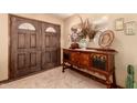 Foyer showcasing a decorative wood table, mirror, artwork, tiled floor, and double front door for a stylish entrance at 2232 E Inglewood St, Mesa, AZ 85213