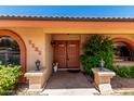 A beautiful front entryway featuring double doors, decorative lanterns, and lush landscaping with a 'Welcome' mat at 2232 E Inglewood St, Mesa, AZ 85213