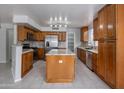 Spacious kitchen featuring granite counters, an island, stainless steel appliances and wood cabinetry at 24709 N 75Th Way, Scottsdale, AZ 85255