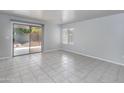 Bright, open living room with tiled floors, large windows, and a sliding glass door leading to the backyard at 24709 N 75Th Way, Scottsdale, AZ 85255