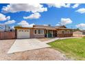 Inviting single-story home featuring a covered front porch, lush lawn, and a convenient attached garage on a sunny day at 25615 S Lemon Ave, Queen Creek, AZ 85142