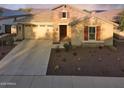Inviting single-Gathering home with stone accents, lush landscaping, and a spacious driveway leading to a two-car garage at 2727 N Acacia Way, Buckeye, AZ 85396