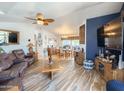 Spacious living room featuring wood floors, ceiling fan, and comfortable leather seating at 3104 E Broadway Rd # 212, Mesa, AZ 85204