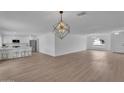 Open-concept living space featuring laminate floors, modern lighting, and a breakfast bar at 3307 N Apollo Dr, Chandler, AZ 85224