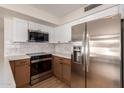 Modern kitchen featuring stainless steel appliances, white cabinetry, and stylish backsplash for a contemporary look at 3841 E Esplanade Ave, Gilbert, AZ 85297