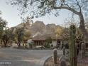 Charming home with beautiful landscaping, featuring a tile roof and set against a backdrop of scenic mountains at 4747 E Arroyo Verde Dr, Paradise Valley, AZ 85253