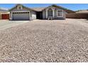 Charming single-story home with a two-car garage, desert landscaping, and a cozy front bench at 723 S Weaver Dr, Apache Junction, AZ 85120