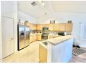 Bright kitchen with light wood cabinets, stainless steel appliances, and tile flooring at 723 S Weaver Dr, Apache Junction, AZ 85120