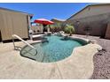Beautiful backyard pool featuring rock accents, palm trees, and a shady pergola nearby at 723 S Weaver Dr, Apache Junction, AZ 85120