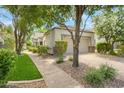 Charming single-story home with a well-maintained front yard, mature trees, and attached two-car garage at 7272 E Gainey Ranch Rd # 117, Scottsdale, AZ 85258