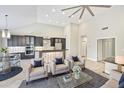 Open-concept living room with high ceilings, modern furnishings, and an adjacent kitchen area at 7272 E Gainey Ranch Rd # 117, Scottsdale, AZ 85258