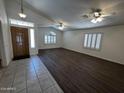 Bright living room features wood laminate flooring, vaulted ceiling, and ample natural light from the windows at 8006 W Gibson Ln, Phoenix, AZ 85043