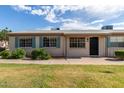 Cozy single-story residence enhanced by a manicured lawn, blue shutters, and a welcoming entrance at 849 N Revere -- # E, Mesa, AZ 85201