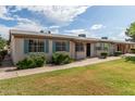 Neat single-story home with blue shutters, green lawn, and a convenient pathway to the entrance at 849 N Revere -- # E, Mesa, AZ 85201