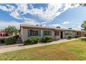 Inviting single-story property showcasing tidy landscaping, blue shutters, and a paved walkway at 849 N Revere -- # E, Mesa, AZ 85201
