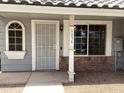 Home entrance features a security door, an arched window, and an entry way with red brick and gravel at 860 N Mcqueen Rd # 1058, Chandler, AZ 85225