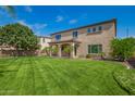 Expansive backyard featuring a well-maintained lawn and covered patio, ideal for outdoor gatherings at 881 E Boston St, Gilbert, AZ 85295