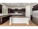 Modern kitchen with dark wood cabinets, stainless steel appliances, and a granite-topped island at 881 E Boston St, Gilbert, AZ 85295