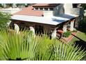 Covered backyard patio with a terracotta tile floor, brick columns, and green garden views at 9430 S 47Th Pl, Phoenix, AZ 85044