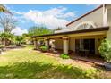 Spacious backyard with covered patio, brick pillars, lush green lawn, and mature landscaping at 9430 S 47Th Pl, Phoenix, AZ 85044