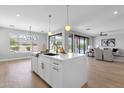 Bright, modern kitchen with large center island featuring white quartz countertops, breakfast bar, and stainless steel faucet at 1526 E Glacier Pl, Chandler, AZ 85249