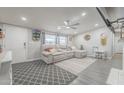 Bright living room featuring a comfortable gray sofa, ceiling fan, and modern decor at 156 N Hawes Rd # 68, Mesa, AZ 85207