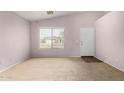 Bright living room featuring neutral carpet and an entry door at 15835 W Woodlands Ave, Goodyear, AZ 85338