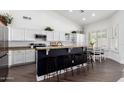 Bright kitchen with granite countertops, dark wood flooring, a breakfast bar, and white cabinetry at 16023 S 30Th Pl, Phoenix, AZ 85048