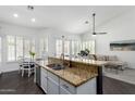 An open-concept kitchen with a granite countertop, stainless steel appliances, and views into the living area at 16023 S 30Th Pl, Phoenix, AZ 85048