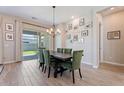 Open dining room with wood floors, stylish light fixture, and sliding doors to the backyard at 1895 N 141St Ave, Goodyear, AZ 85395