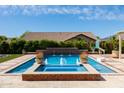 Backyard pool with water features, beautiful landscaping and a basketball hoop at 20585 W Garden St, Buckeye, AZ 85396