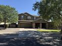 Inviting two-story home with a spacious driveway, beautiful stone accents and lush, green lawn at 2735 E Flower Ct, Gilbert, AZ 85298