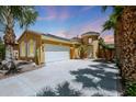 Charming exterior view showcasing the home's desert landscaping and well-maintained two-car garage at 30248 W Earll Dr, Buckeye, AZ 85396