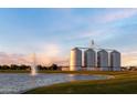 Scenic view featuring a community lake with a fountain and large silos against a pastel sky at 3437 E Appaloosa Rd, Gilbert, AZ 85296