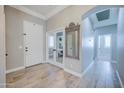 Elegant foyer with wood-look tile flooring, arched doorways, and a view into a bright office space at 3736 E Cotton Ct, Gilbert, AZ 85234