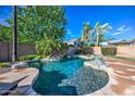 Gorgeous freeform pool with stone accents and lush landscaping, perfect for outdoor relaxation at 3736 E Cotton Ct, Gilbert, AZ 85234
