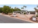 Classic single-story home with circular driveway, manicured landscaping, and mature palm trees at 4107 E Fairview Cir, Mesa, AZ 85206