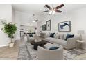 Open-concept living room with neutral decor, ceiling fans, and views into dining and kitchen areas at 4107 E Fairview Cir, Mesa, AZ 85206