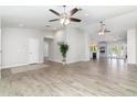 Open-concept living area featuring wood-look tile, neutral paint, and seamless flow to the kitchen at 4107 E Fairview Cir, Mesa, AZ 85206